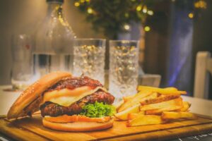 Gourmet burger and fries on wooden board at restaurant